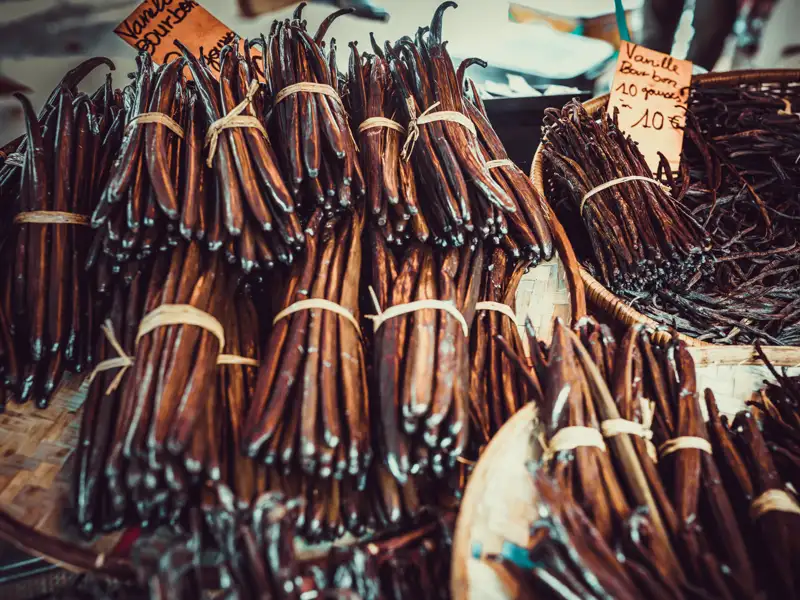 Gebündelte Vanilleschoten auf einem Marktstand.