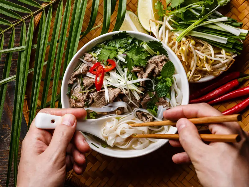 Eine Person isst eine Schüssel Pho, eine vietnamesische Nudelsuppe.
