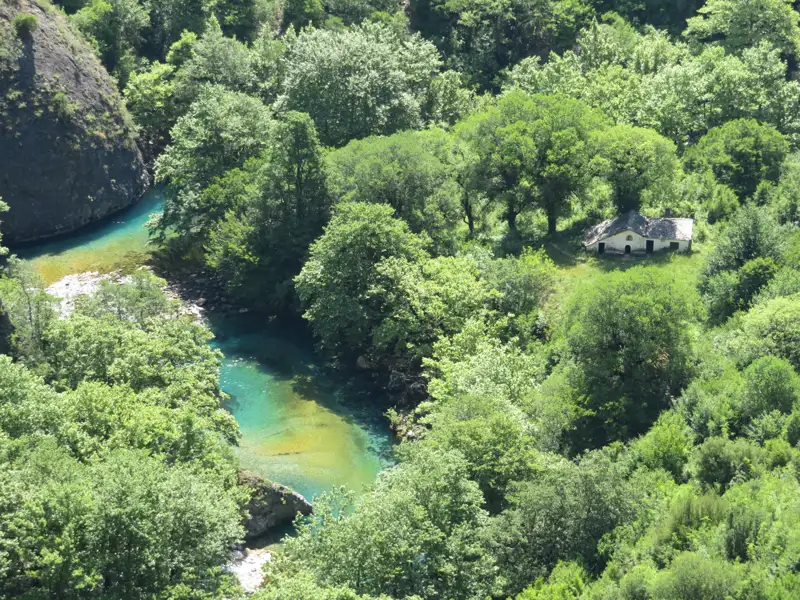Fluss und Haus inmitten grüner Landschaft