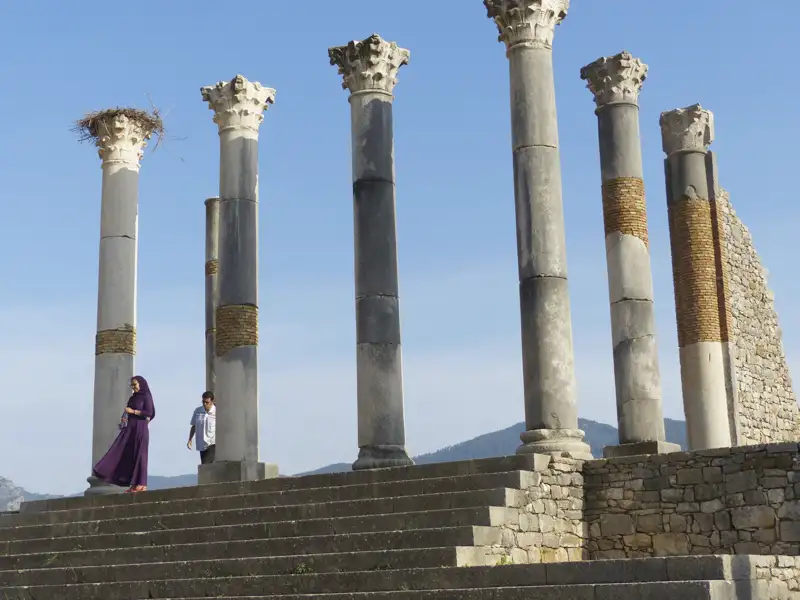 Antike Säulen einer historischen Stätte mit Besuchern im Vordergrund.