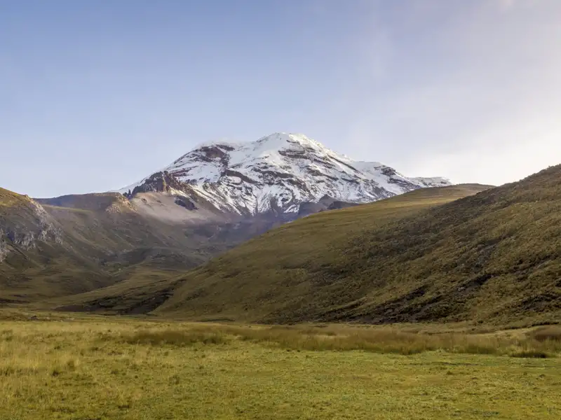 Panoramablick auf einen schneebedeckten Berg und das grüne Tal.