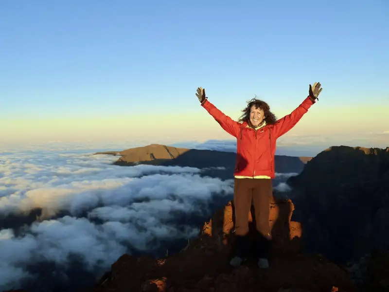Wanderer genießt den Ausblick vom Berggipfel über den Wolken.