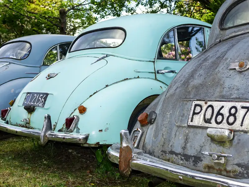 Heckansicht von geparkten Morris Minor Oldtimern.  Der Lack ist teilweise abgenutzt und rostig.
