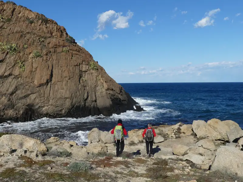 Zwei Wanderer an der Küste mit Blick auf das Meer.