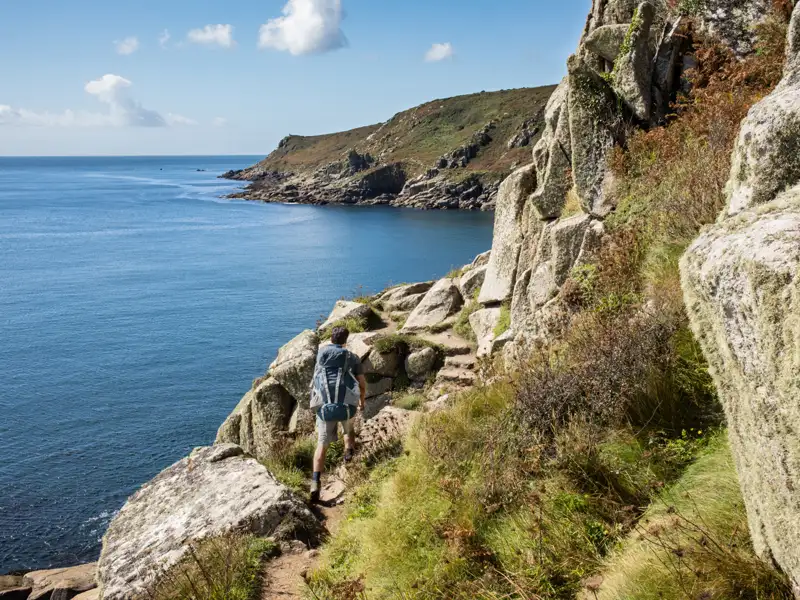 Wanderer auf einem Küstenpfad mit Blick auf das Meer.