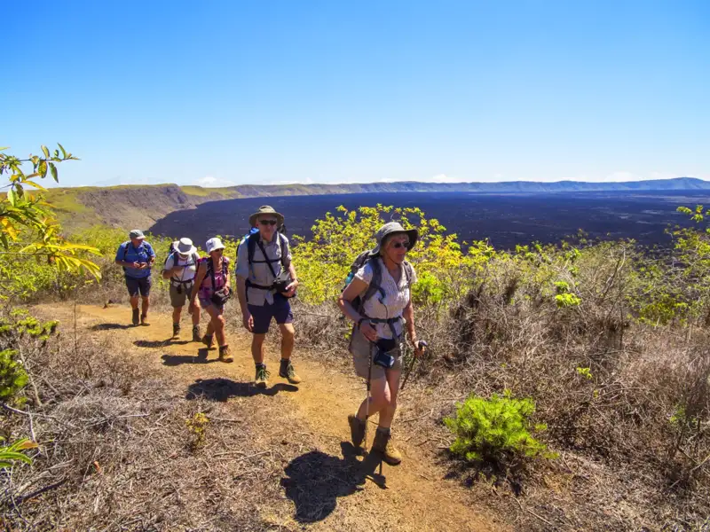 Wanderer auf einem Pfad in der Nähe eines Lavafeldes.