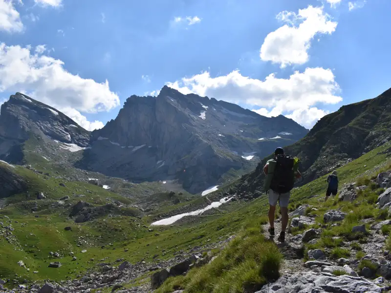 Wanderer auf einem Bergpfad mit Blick auf die Gipfel.