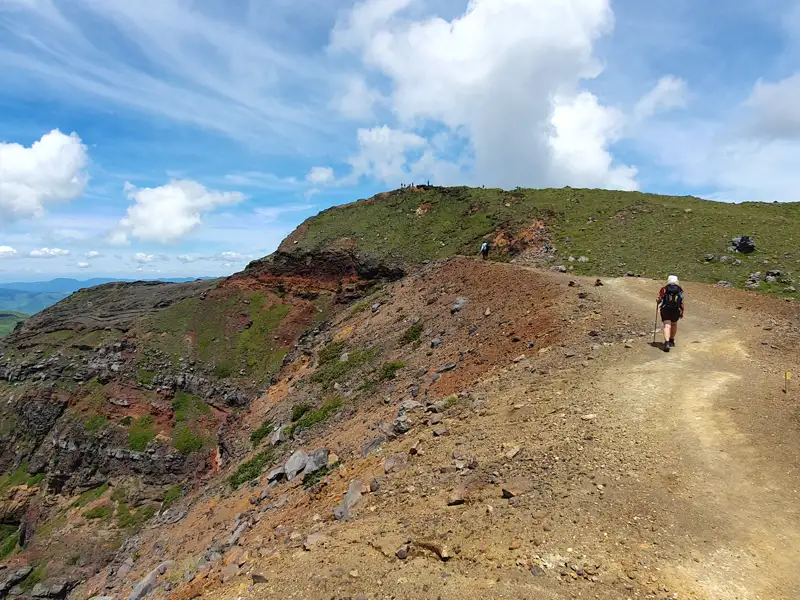 Wanderer auf einem Bergpfad mit Blick auf die umliegende Landschaft.