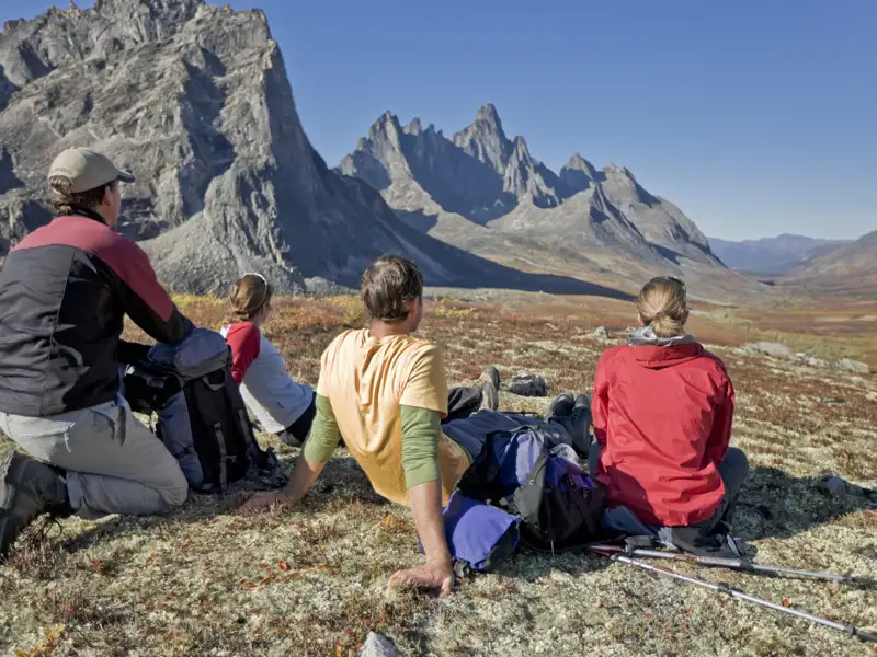 Wanderer machen eine Pause während ihrer Bergtour und bewundern die Landschaft.