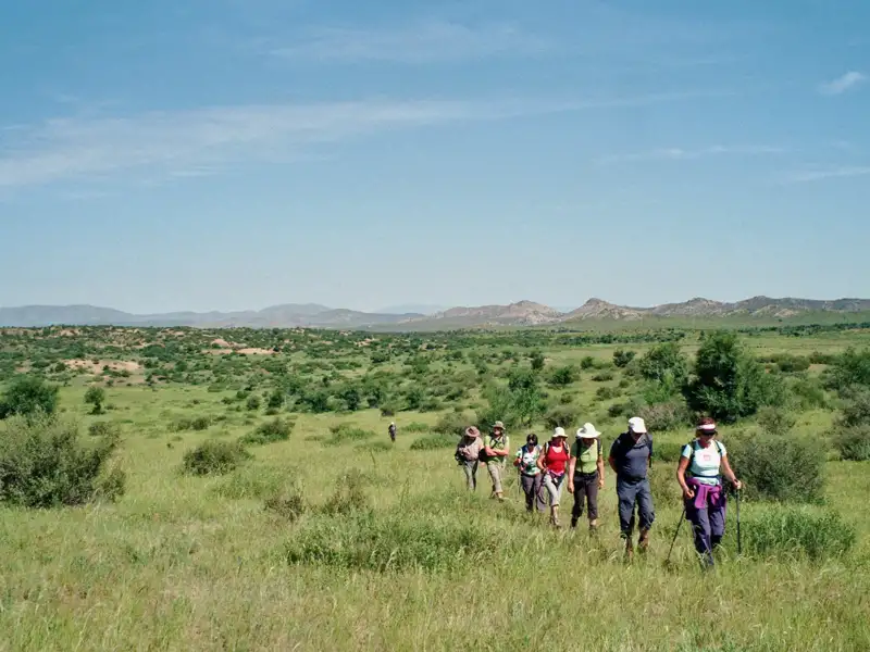 Wandergruppe auf einem Wanderweg in einer natürlichen Landschaft.