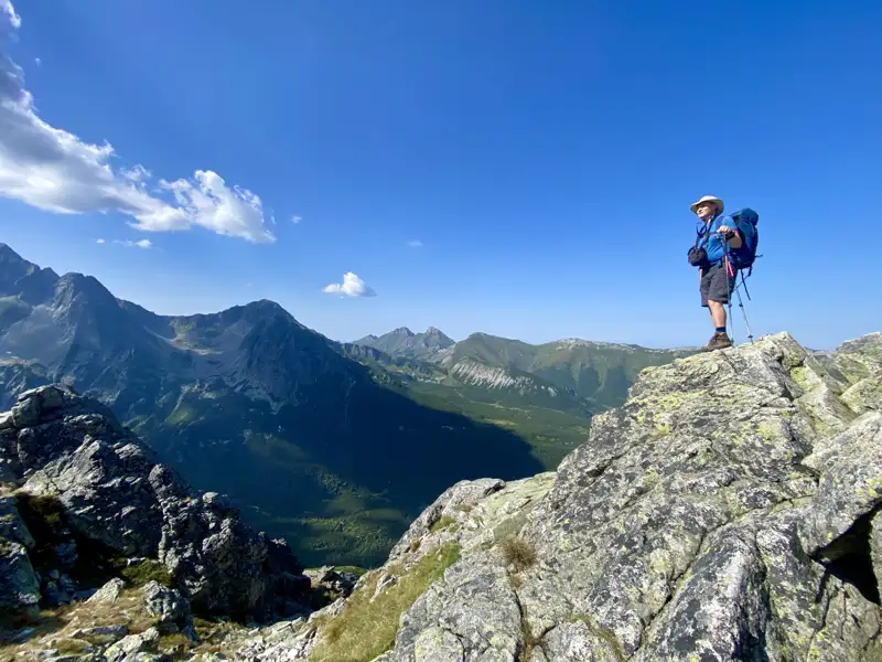 Wanderer auf einem Berggipfel mit Blick auf das Tal.