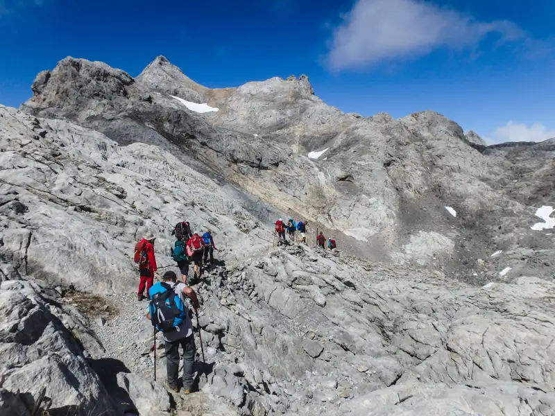 Wanderer auf einem felsigen Bergpfad in den Bergen.