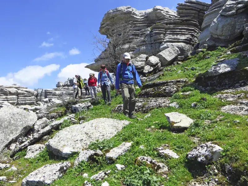 Wanderer auf einem Pfad durch eine felsige Landschaft mit ungewöhnlichen Gesteinsformationen.