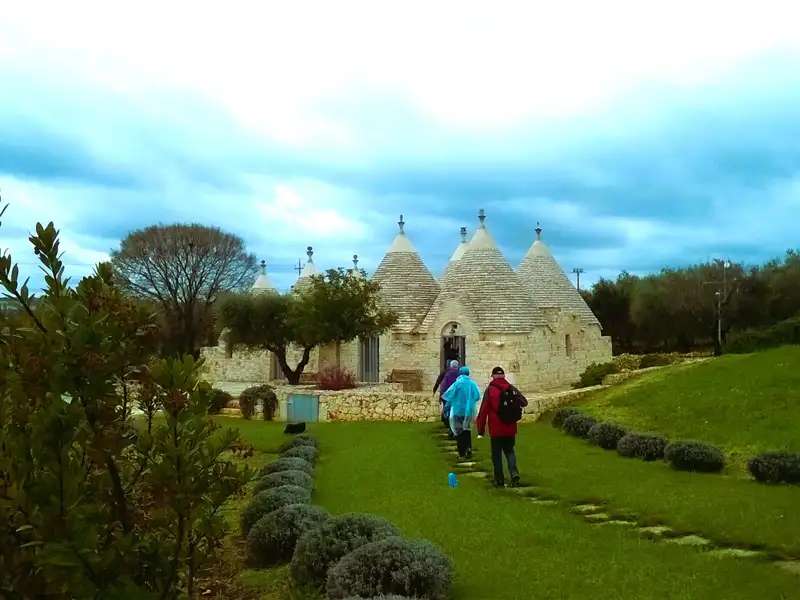 Wanderer auf dem Weg zu den Trulli.