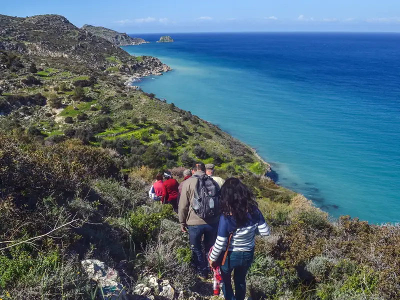 Wandergruppe auf einem Küstenpfad mit Blick auf das Meer.