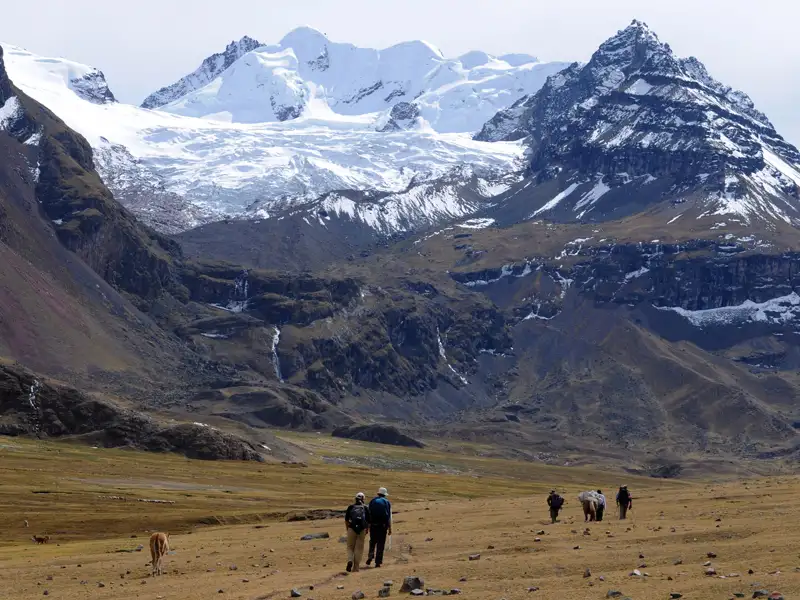 Wanderer in den Anden mit schneebedeckten Bergen und Gletschern im Hintergrund.