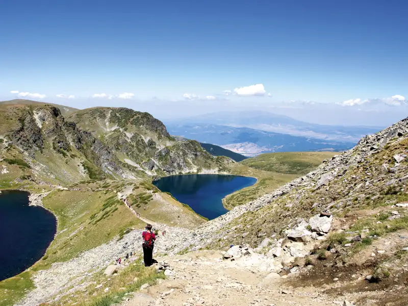 Wanderweg zu einem Bergsee inmitten einer Berglandschaft.