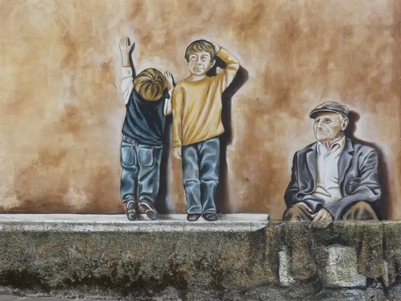 Wandgemälde mit zwei Kindern und einem älteren Mann.