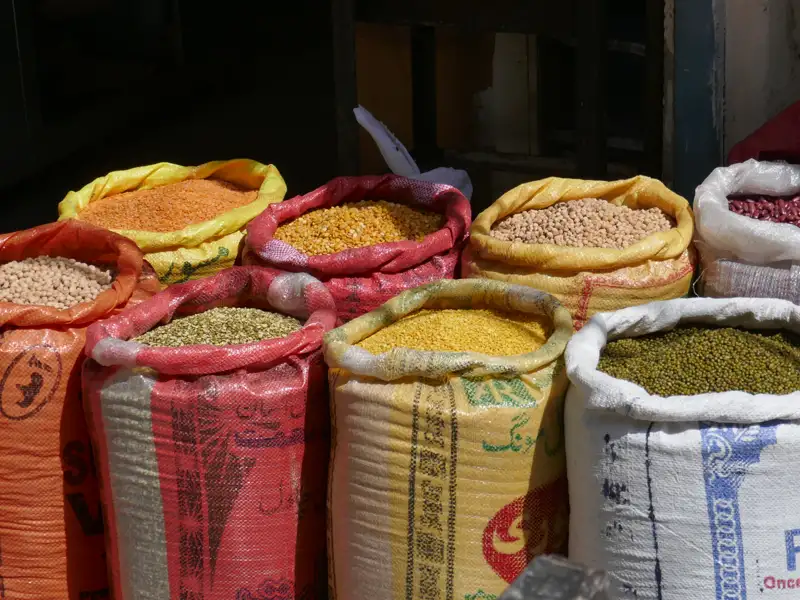 Säcke voller verschiedener Hülsenfrüchte auf einem Markt.