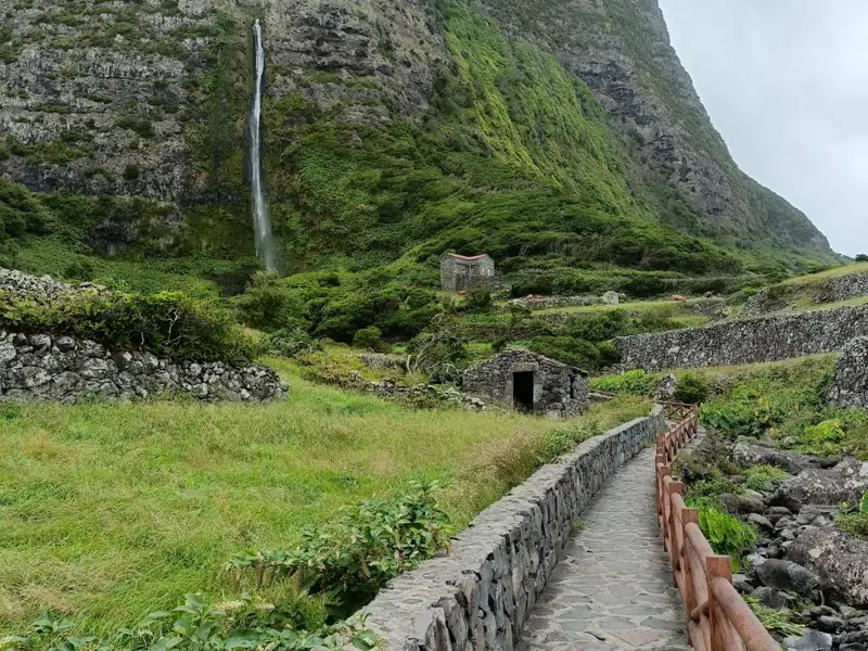 Wanderweg mit Wasserfall und Steinmauern