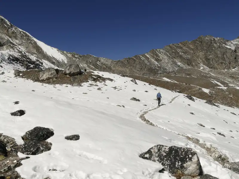 Wanderer auf einem schneebedeckten Bergpfad in den Bergen.