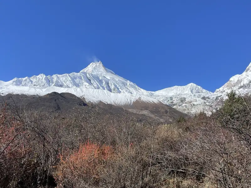 Schneebedeckte Bergkette unter blauem Himmel.