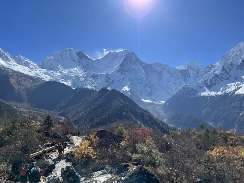 Wanderweg in den Bergen mit Blick auf schneebedeckte Gipfel.