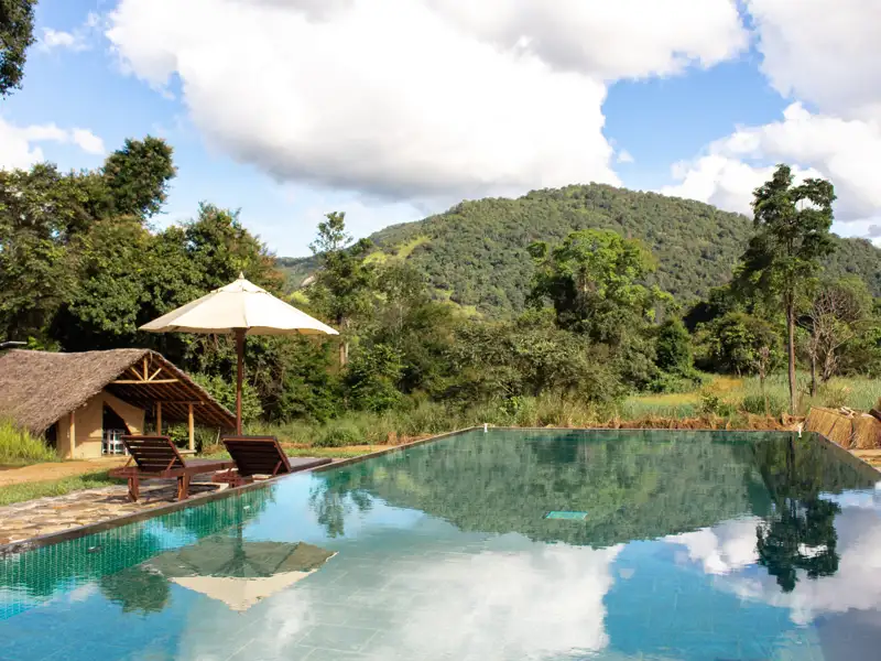 Pool und Hütte mit Blick auf die bewaldeten Hügel.