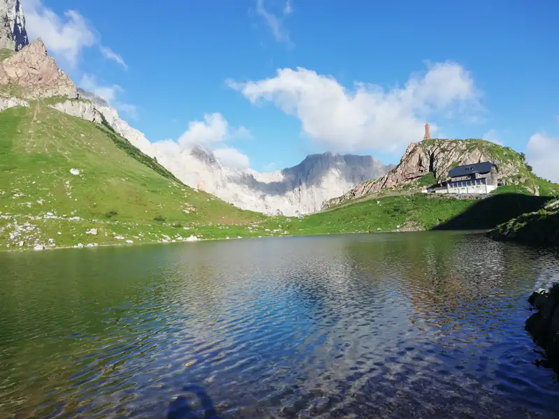 Alpenpanorama mit Bergsee und Hütte