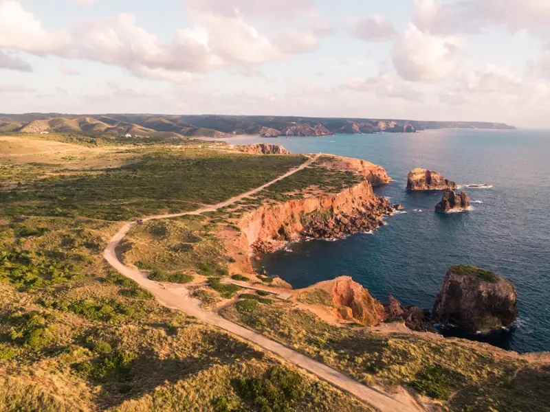 Felsige Küste mit einer Schotterstraße, die sich entlang der Klippen schlängelt.