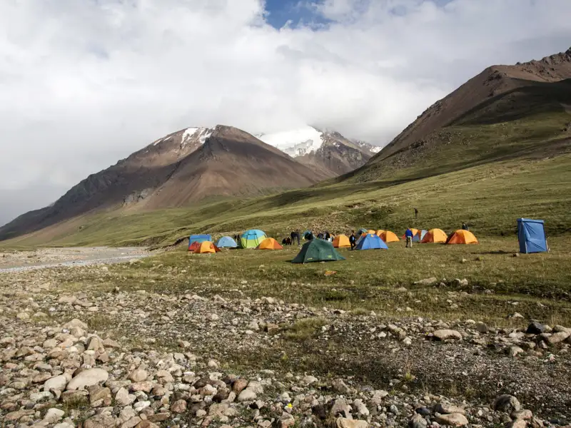 Zelte aufgestellt in einem Basislager am Fuße eines schneebedeckten Berges.
