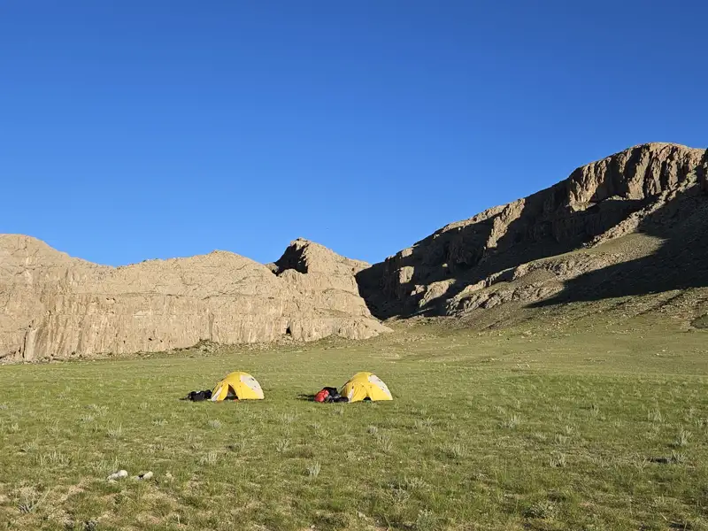Campingplatz mit zwei Zelten in einer Gebirgslandschaft.