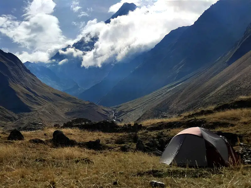 Zeltplatz in einem Gebirgstal mit Blick auf die umliegenden Berge.