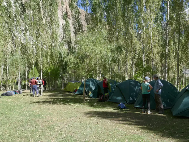 Campingplatz mit mehreren Zelten und Reisenden.