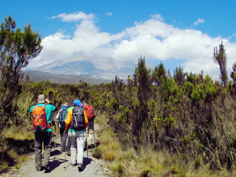 Wandergruppe auf einem Bergpfad in Richtung eines Vulkans.