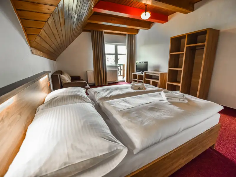 Gemütliches Schlafzimmer mit zwei Einzelbetten und Holzmöbeln.