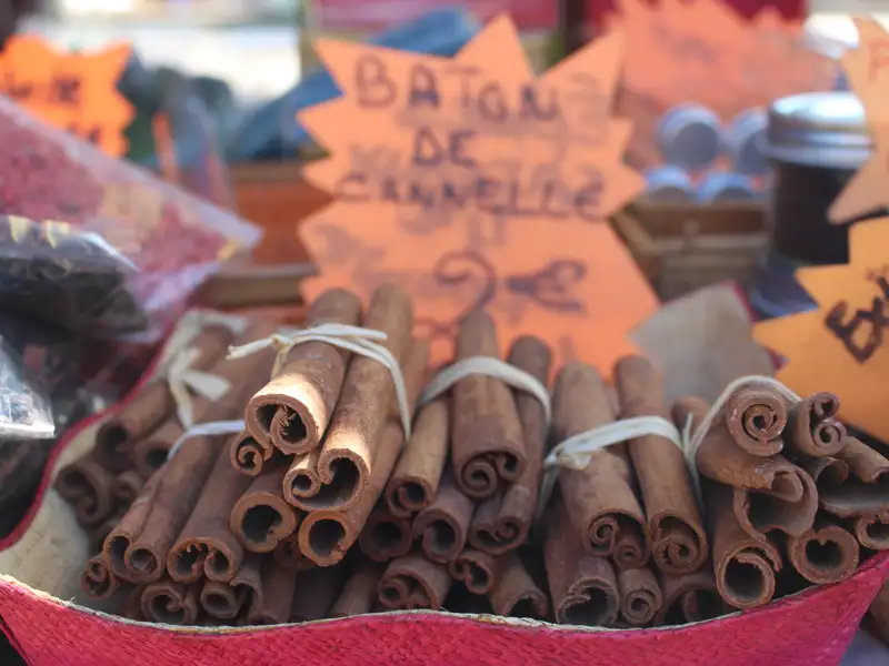 Gebündelte Zimtstangen auf einem Marktstand, möglicherweise Teil eines lokalen Marktes oder einer Gewürzauswahl.