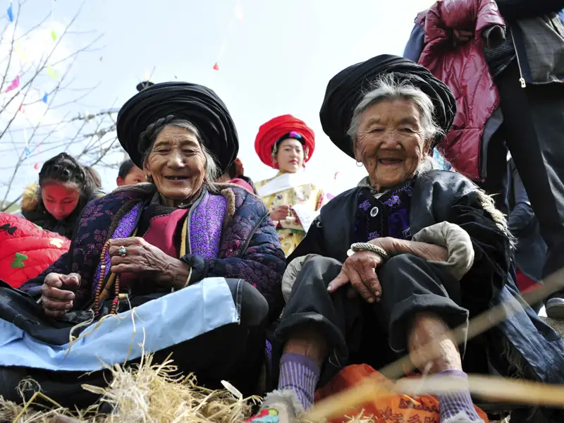 Zwei ältere Frauen in traditioneller Kleidung, möglicherweise bei einer kulturellen Veranstaltung.