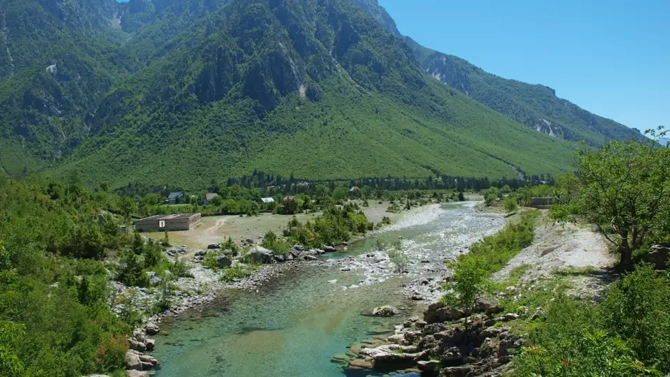 Klares Flusswasser fließt durch eine Berglandschaft.